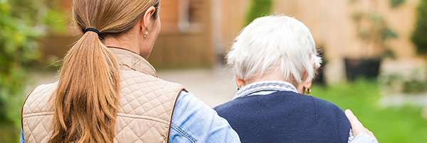 Back of senior woman and young woman walking outside