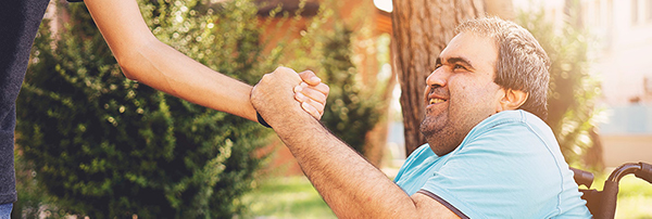 Man with disability holding hand with companion