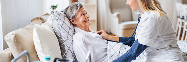 Carer doing health check on senior woman