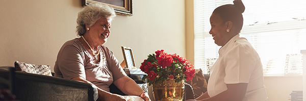 Carer helping senior woman with her shoes