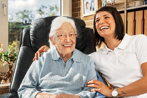 Elderly woman and young woman laughing together